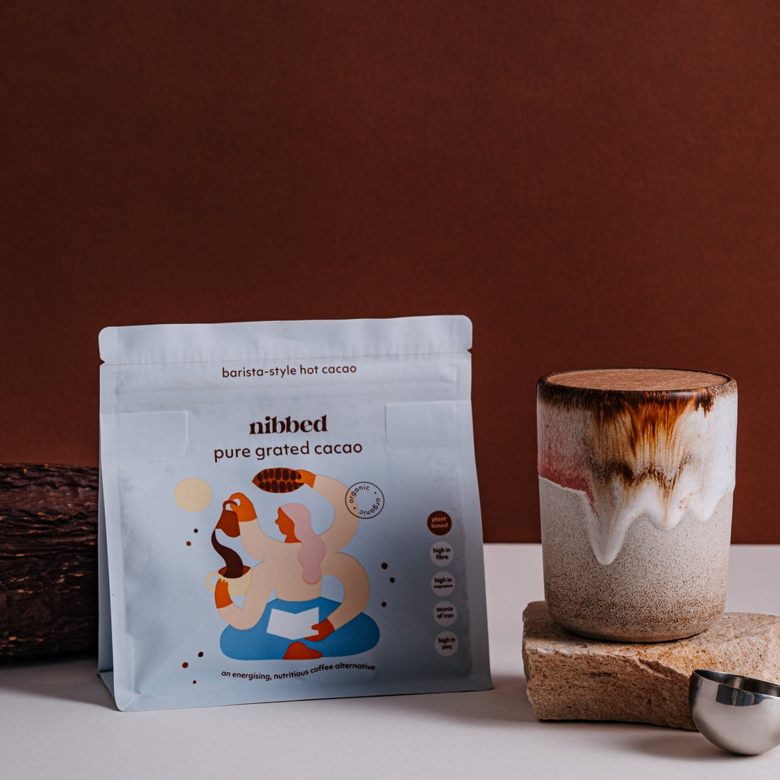 Cacao packaging and ceramic cup on a table with a brown background